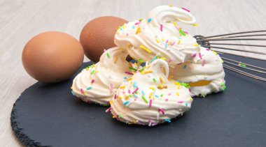 Yumurta ve şeker de dahil olmak üzere onları yaratmak için gerekli malzemelerle bezenmiş kremalar.