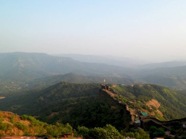 Mahabaleshwar 'daki tepelerin ve gökyüzünün puslu arka planına sahip tepe manzarası Maharashtra-Hindistan