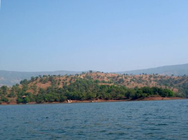 Nehirde akan sular tepelerin ardında puslu mavi gökyüzü Mahabaleshwar-maharstra-Hindistan 'da