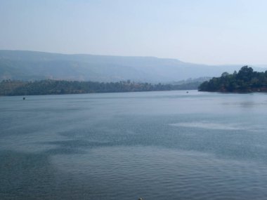 Nehirde akan sular tepelerin ardında puslu mavi gökyüzü Mahabaleshwar-maharstra-Hindistan 'da