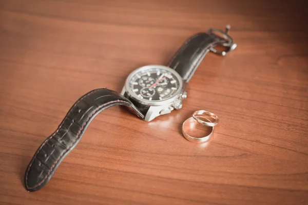Dva snubní prsteny a Pánské hodinky — Stock fotografie