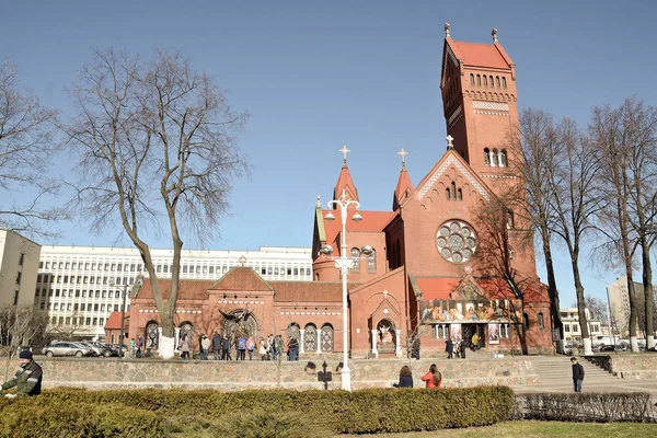 Minsk, Beyaz Rusya - 23 Şubat 2017. Kırmızı Katolik Kilisesi St Simon ve Alena Minsk'te Merkezi. Güzel kentsel peyzaj. İlkbahar ve yaz saati, insanlar yürümek, zemin üzerine mavi gökyüzü. — Stok fotoğraf