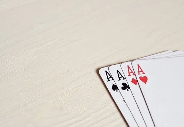 Cuatro ases manos de póquer jugando cartas sobre un fondo de escritorio de luz . — Foto de Stock