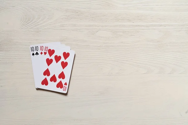 Cuatro diez cartas de juego en el escritorio de luz . — Foto de Stock