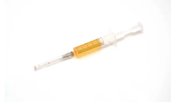 白い背景と黄色の液体の中に注射器。薬物や薬物. — ストック写真