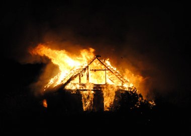 Fire village house at night. A big fire swept through the whole building clipart