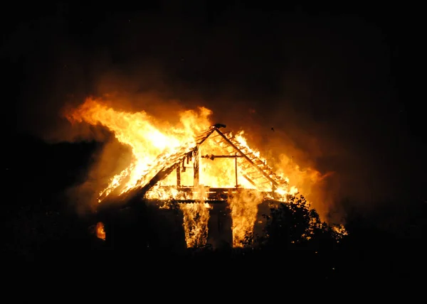 Maison de village de pompiers la nuit. Un grand feu a balayé tout le bâtiment — Photo