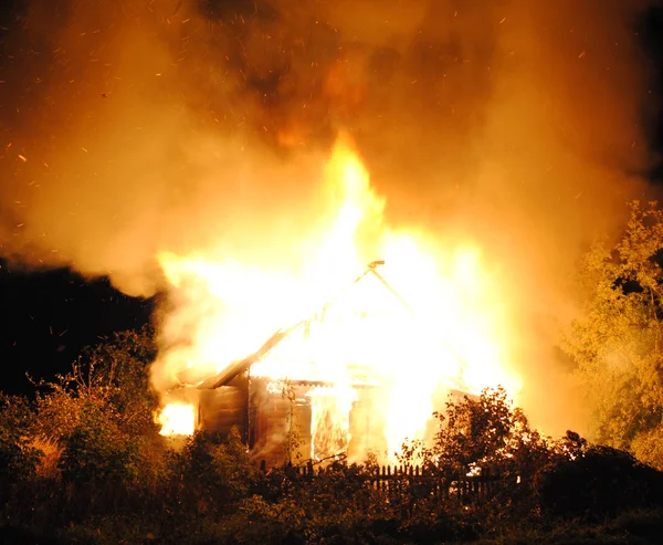 Huis brand met zware vlam, gloeiende dak en schoorsteen. — Stockfoto