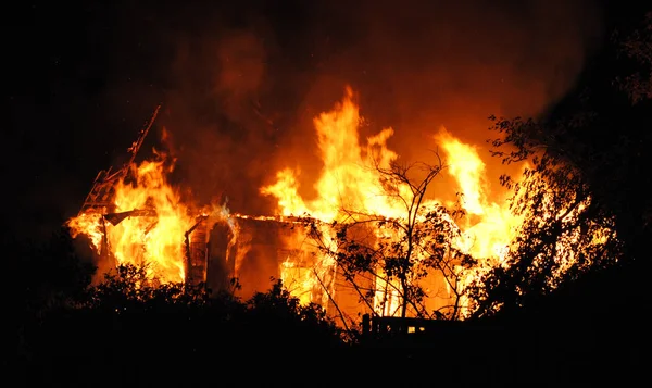 Пожар в большом доме ночью — стоковое фото