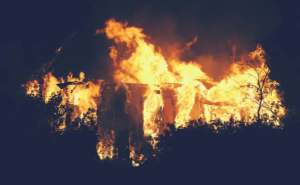 Grande casa de fogo na noite ligjt foto tonificada — Fotografia de Stock