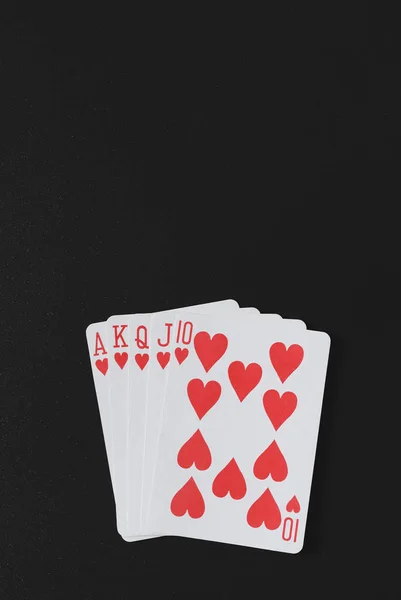 皇家同花顺扑克手上一个黑色的背景、 扑克牌、 copyspace 为你营销文本垂直照片 — 图库照片