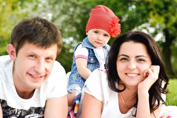 Szczęśliwa rodzina w parku, skupić się na dziecko — Zdjęcie stockowe