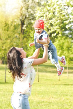 Genç anne ile bebeği parkta oynarken