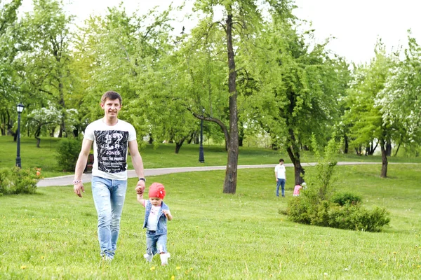 Père et petite fille marchant dans l'herbe verte — Photo