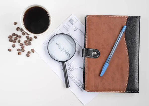 Forex trading abstract. Stock exchange fluctuations, magnifier and notebook on white. coffee cup with coffee beans
