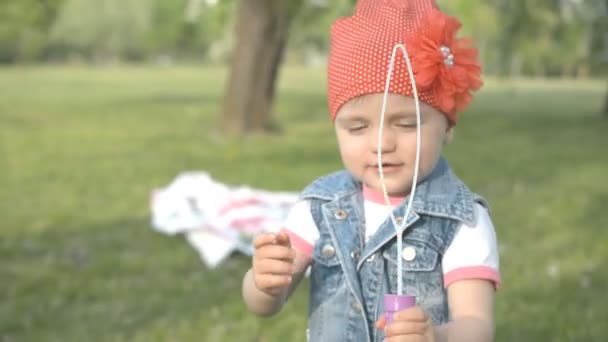 Little girl in the park try make soap bubble — Stock Video