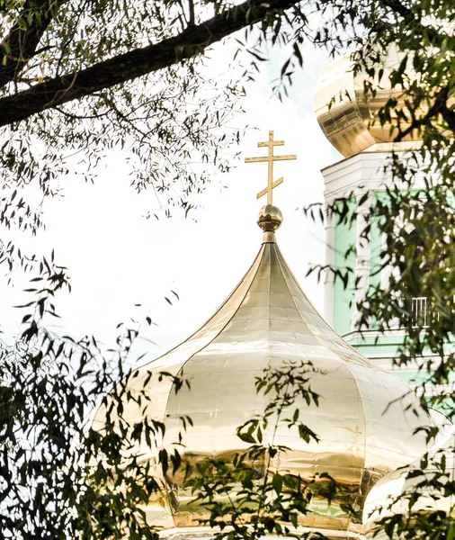 Le dôme d'or de l'église orthodoxe vue à travers les arbres — Photo