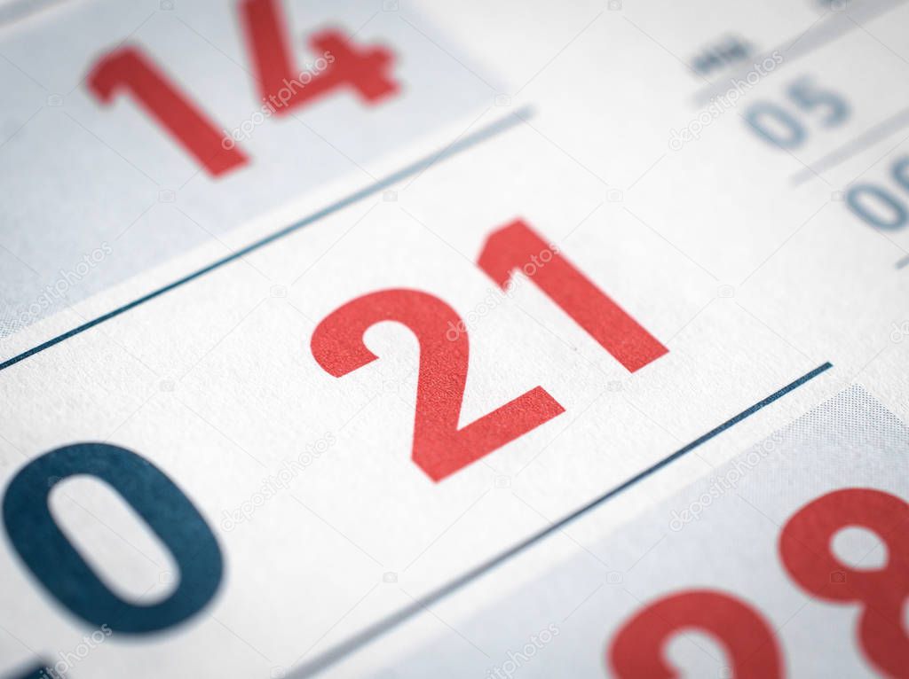 calendar close up. the twenty-first red number in focus