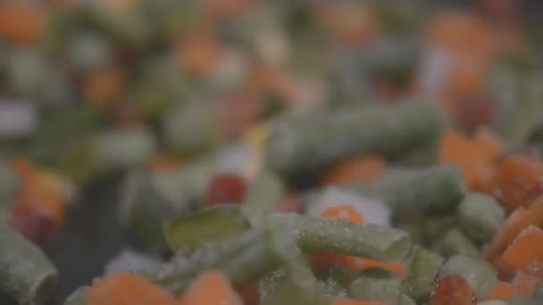 Fagyasztott zöldségek főzés egy serpenyőben közelről hd felvételeket lassú mozgás — Stock videók