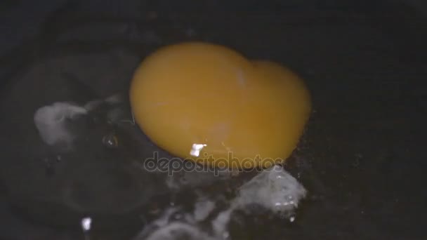 Images macro HD d'un oeuf déposé dans une poêle, tandis qu'un deuxième est fissuré et déposé dans .