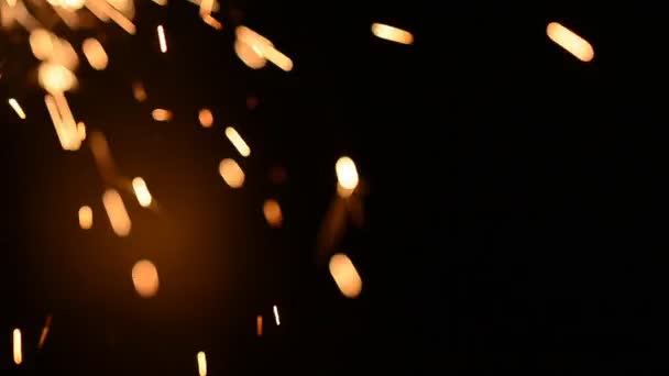 Feu d'artifice scintillant brûlant isolé au ralenti à partir du bas gauche en prise de vue macro. Pistolet poudre étincelles tourné sur fond sombre profond — Video