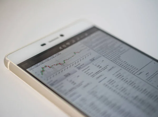 Смартфон на столе Графики финансовых рынков для роста биткойнов и других криптовалют — стоковое фото