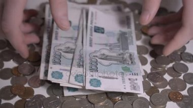 Rus parası Moloztaşlar ve sikkeler üzerinde beyaz masa el sayısı para ağır çekim hd görüntüleri soyut