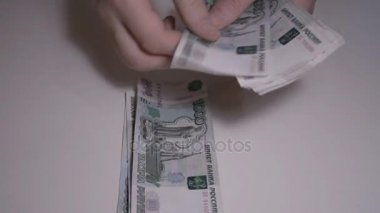 Adam para Rus Rublesi beyaz masa ağır çekim hd görüntüleri sayar.