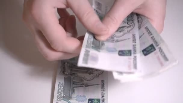 Ryska pengar rubbles över vitt bord händerna räkna pengar slowmotion hd film — Stockvideo