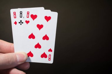 Özet: adam elini tutarak oyun kağıdı üç sekiz izole boşaltmak poker seti dört siyah zemin üzerine sekiz