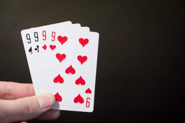 Özet: adam elini tutarak oyun kağıdı dört dokuz izole boşaltmak poker seti dört siyah zemin üzerine dokuz
