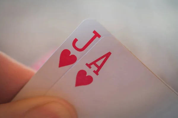 Duas cartas ás e valete de copas, jogar cartas na mão sobre a mesa, nands de poker — Fotografia de Stock