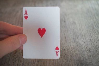 Kupa as 'ı, kupa ası tutan adam, masada kağıt oynayan adam, poker naneleri.