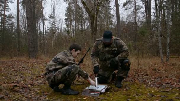 Dos soldados rusos están considerando un mapa en el bosque — Vídeo de stock