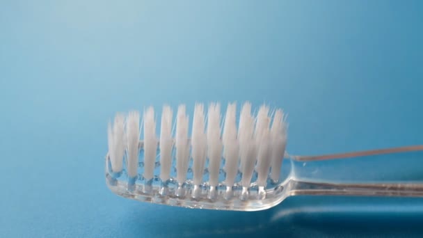 Cepillo de dientes sobre fondo azul y pasta de dientes — Vídeo de stock