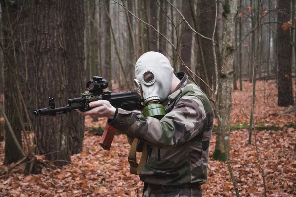 Soldaat gekleed in ghillie pak, mikken met aanvalsgeweer, gasmasker gezicht — Stockfoto