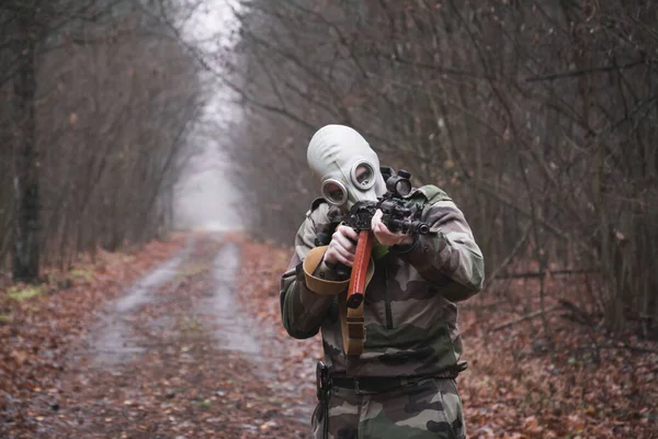 Soldado vestido com terno ghillie, apontando com rifle de assalto, máscara de gás rosto — Fotografia de Stock
