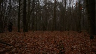 Kalaşnikoflarla donanmış iki Rus askeri akşamları sonbahar ormanlarında koşuyor.