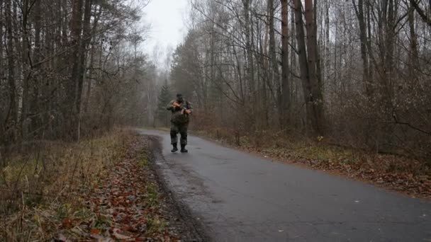 Солдат проходить через осінній ліс — стокове відео