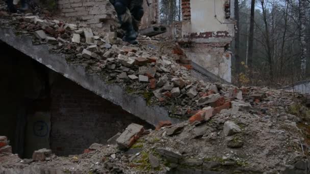 Két orosz katona ereszkedik le a lerombolt épület lépcsőjén. — Stock videók