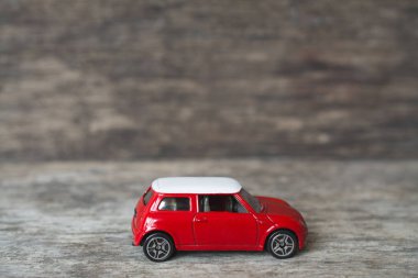 Tahta masada küçük kırmızı oyuncak araba.