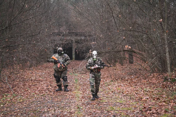 Két fegyveres katona átkel az erdőn, hogy megkeresse az ellenséget. — Stock Fotó