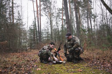 Komando komutanı savaş görevini açıklıyor ve bir haritaya işaret ediyor.