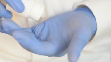 Doktorlar beyaz bir şişeden beyaz ağrı kesiciler ya da müşterisi için antipiretik haplar çıkarıyorlar.