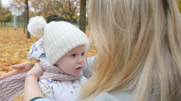 Cuidado de la madre y el amor concepto, mamá envuelve a sus hijas bufanda en el parque de otoño — Vídeos de Stock