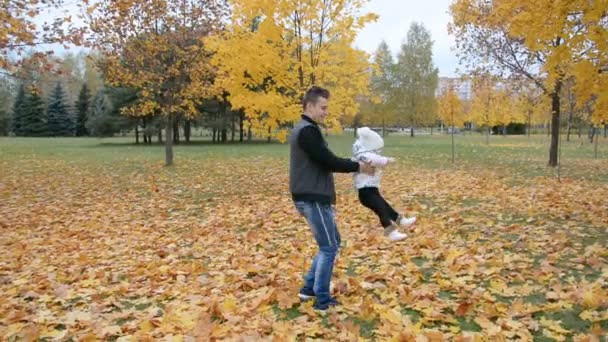 Boldog apa játszik a kislánnyal, apa körözik a kisgyerekkel a szabadban — Stock videók