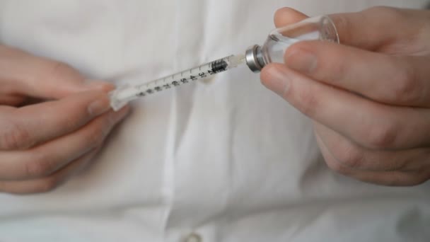 Nahaufnahme eines Mädchens, das Insulin der verlängerten Wirkung mischt und es in der Spritze aufnimmt — Stockvideo