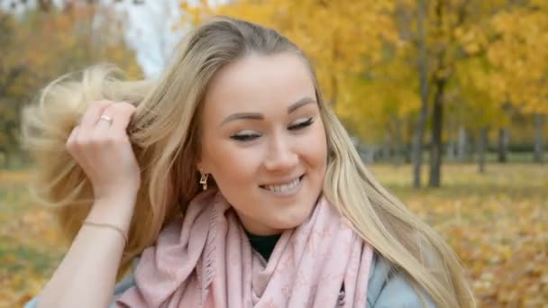 El retrato de una hermosa chica rubia en el parque de otoño — Vídeo de stock