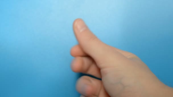 doigts claquant main de l'homme sur fond bleu 