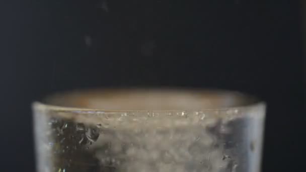 Aspirine Bruisende Pil Vallen Een Glas Water Een Zwarte Achtergrond — Stockvideo